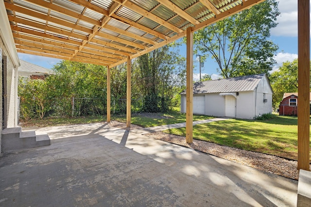 view of patio / terrace with a garage, an outdoor structure, and a pergola