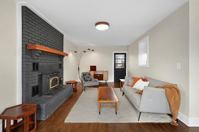 living room with dark wood-type flooring and a brick fireplace