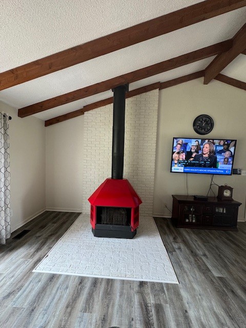 living room featuring vaulted ceiling with beams and hardwood / wood-style floors