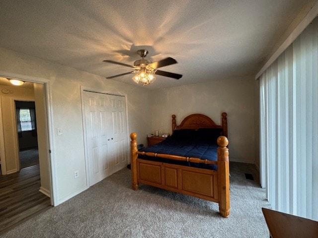 carpeted bedroom featuring ceiling fan, a closet, and a textured ceiling