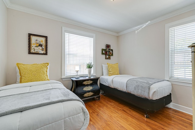 bedroom with wood-type flooring, ornamental molding, and multiple windows