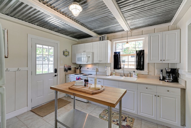 kitchen featuring plenty of natural light, sink, white appliances, and white cabinetry