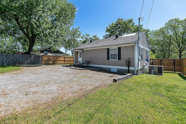 rear view of house featuring cooling unit, a yard, and a patio