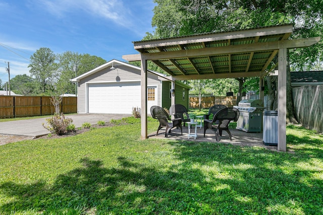 view of yard with an outdoor structure, a garage, and a patio area