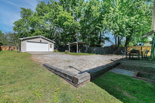 view of yard with a garage and an outbuilding