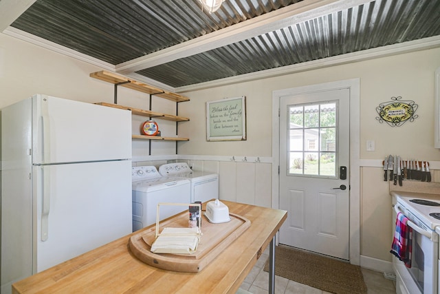 kitchen featuring separate washer and dryer, white appliances, white cabinetry, and light tile patterned floors