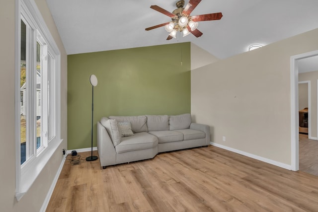 living room featuring light wood-type flooring, a wealth of natural light, lofted ceiling, and ceiling fan