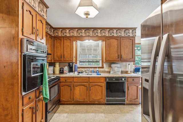 kitchen featuring sink, plenty of natural light, black appliances, and a textured ceiling