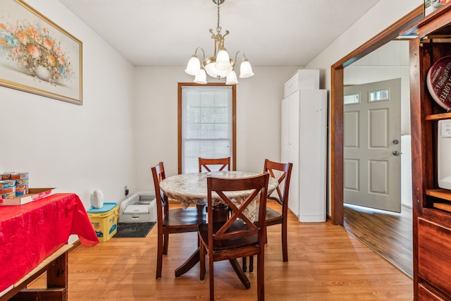 dining space featuring a chandelier and light wood-type flooring