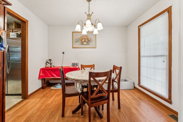 dining room with a notable chandelier and light hardwood / wood-style flooring