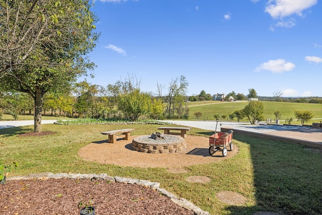 view of home's community with an outdoor fire pit, a yard, and a rural view