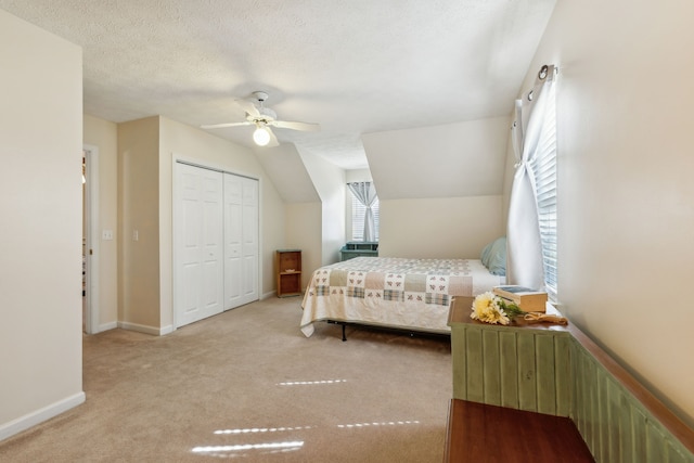 bedroom with ceiling fan, light colored carpet, a closet, and multiple windows