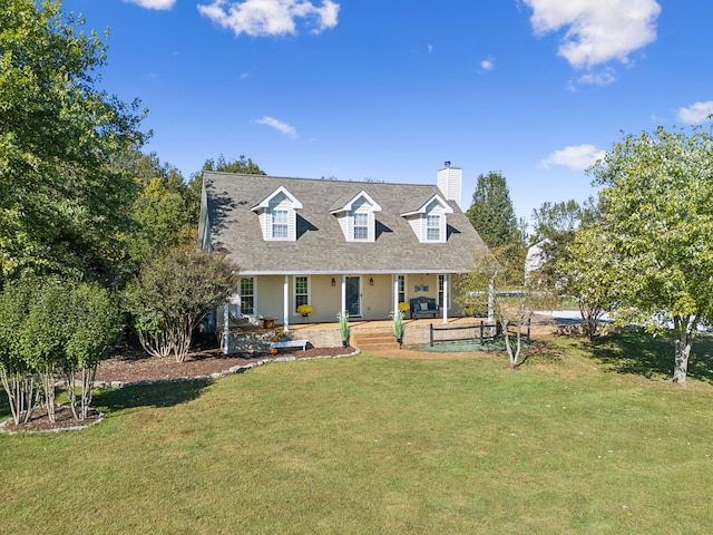 cape cod house with a patio area and a front lawn