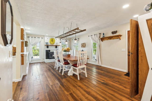 dining room with dark wood-type flooring and a textured ceiling