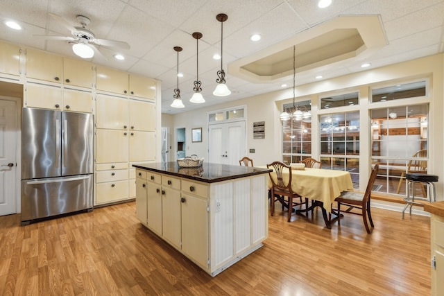 kitchen with pendant lighting, light hardwood / wood-style floors, stainless steel refrigerator, and a center island