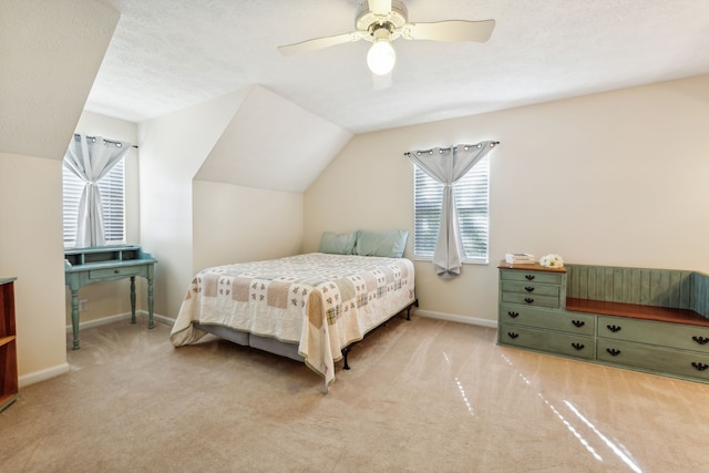 carpeted bedroom with ceiling fan, a textured ceiling, lofted ceiling, and multiple windows