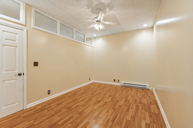 clothes washing area with ceiling fan, hardwood / wood-style floors, and a baseboard radiator