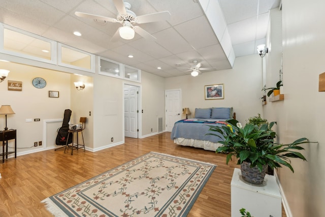 bedroom with a paneled ceiling, ceiling fan, and hardwood / wood-style floors