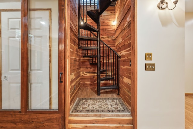 stairs with wood walls and hardwood / wood-style floors