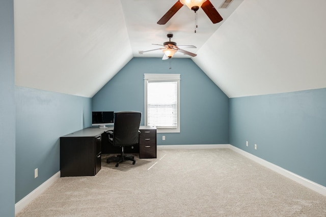 office space featuring light colored carpet, vaulted ceiling, a ceiling fan, and baseboards