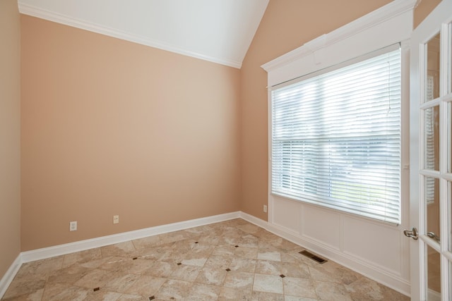 unfurnished room featuring baseboards, vaulted ceiling, visible vents, and a wealth of natural light