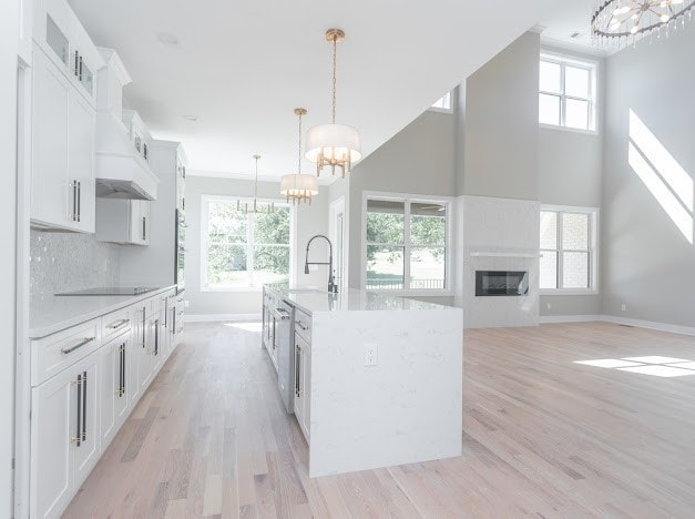 kitchen featuring a center island with sink, decorative light fixtures, and plenty of natural light