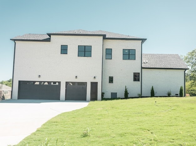 view of side of home featuring a garage and a lawn