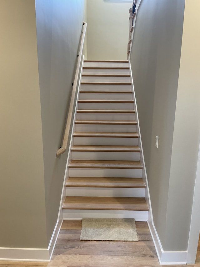 staircase with hardwood / wood-style flooring and a barn door