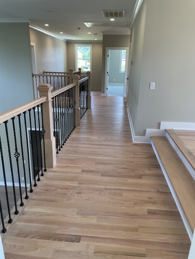 hallway with ornamental molding and light wood-type flooring