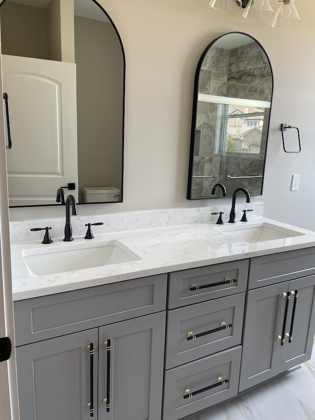 bathroom featuring a shower with shower door, vanity, and toilet