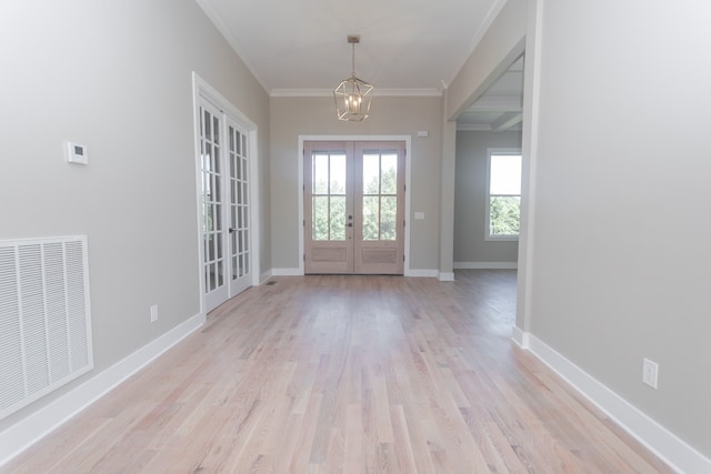 entryway with french doors, a notable chandelier, light wood-type flooring, and crown molding