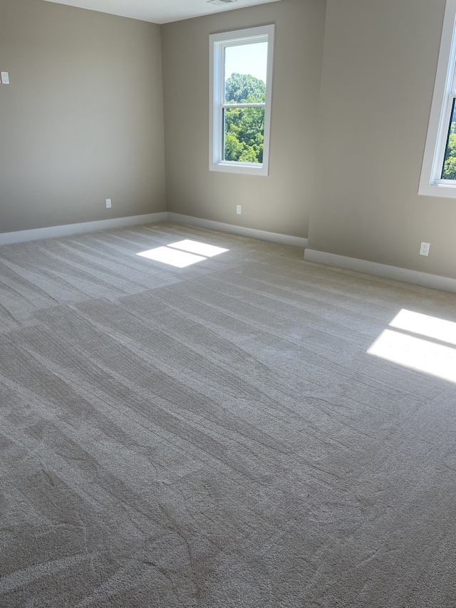 carpeted spare room featuring a healthy amount of sunlight