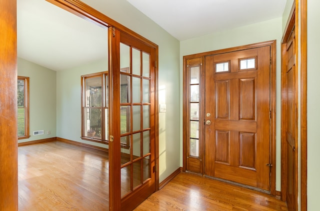 entryway with light hardwood / wood-style flooring and vaulted ceiling