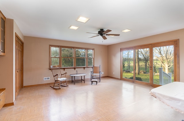 sitting room featuring a healthy amount of sunlight, ceiling fan, and light parquet flooring