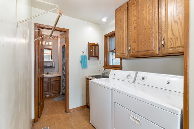 laundry area featuring separate washer and dryer, cabinets, and sink