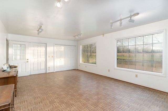 unfurnished bedroom with two closets and light parquet flooring