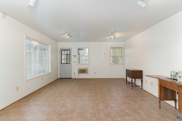 living room featuring a wall mounted air conditioner and light parquet flooring