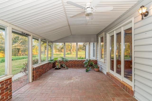 unfurnished sunroom with lofted ceiling, a wealth of natural light, and ceiling fan