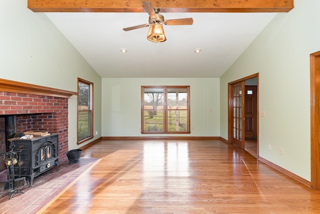 unfurnished living room with a wood stove, high vaulted ceiling, beamed ceiling, and wood-type flooring