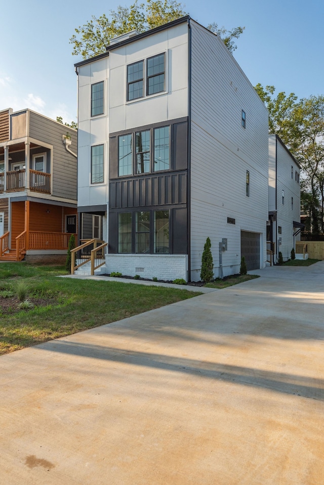 rear view of house featuring a balcony and a garage