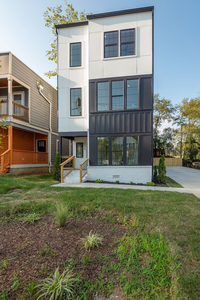 rear view of house with a balcony and a lawn