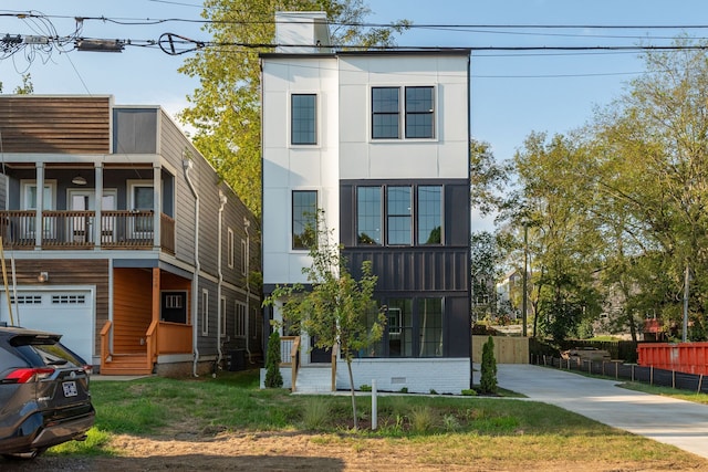 view of front facade with a front lawn, central AC unit, a balcony, and a garage