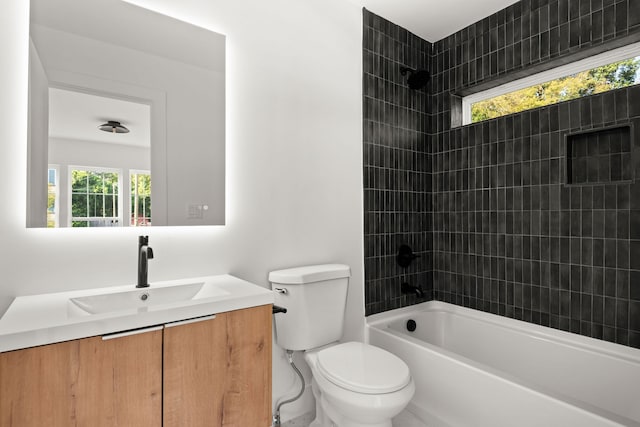 full bathroom with a healthy amount of sunlight, tiled shower / bath combo, vanity, and toilet