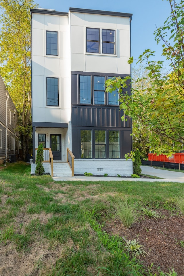 back of property featuring central AC and a lawn