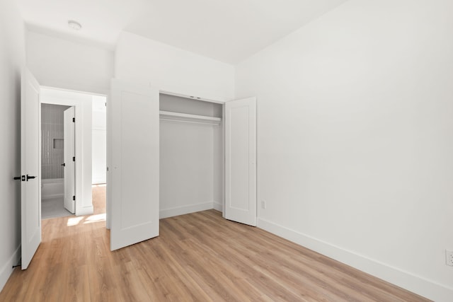 unfurnished bedroom with light wood-type flooring and a closet