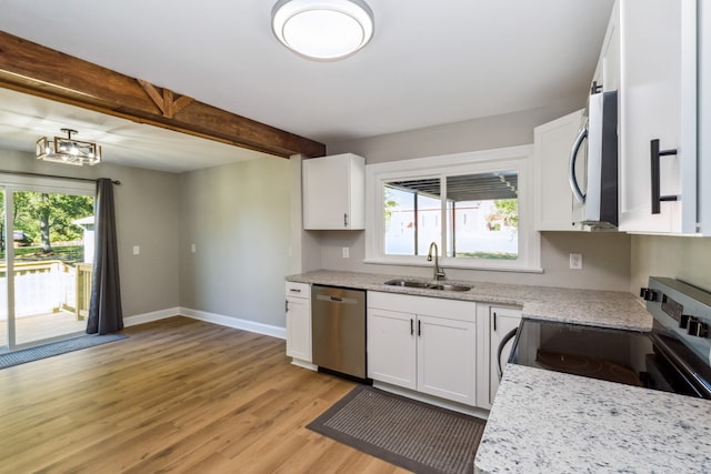 kitchen with stainless steel appliances, plenty of natural light, sink, and white cabinetry