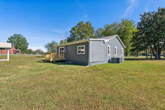 view of side of home featuring a yard, a wooden deck, and central air condition unit