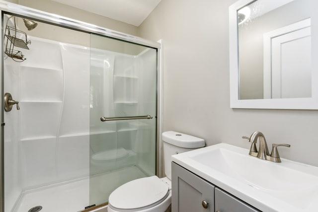 bathroom featuring vanity, a shower with shower door, and toilet