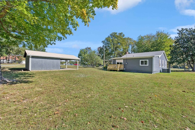 view of yard featuring a wooden deck, central AC unit, and an outdoor structure