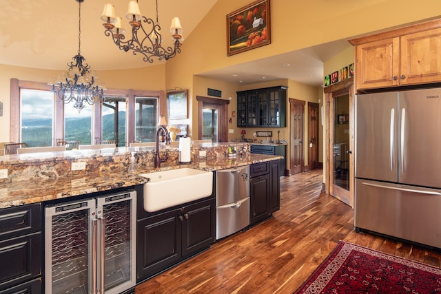 kitchen featuring lofted ceiling, light stone countertops, dark wood-type flooring, sink, and stainless steel appliances